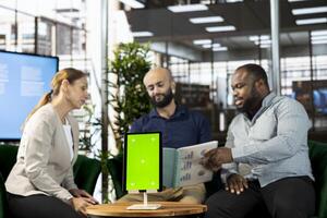 Startup CEO attends meeting to talk about new business vision with executive board member, using isolated screen tablet. Men using mockup device to pitch investment strategy to manager photo