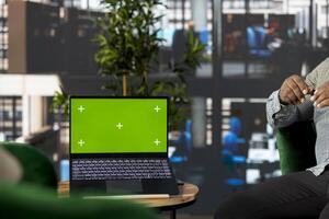 Startup CEO attends meeting to talk about new business vision with executive board member, using green screen laptop. Employee using mockup notebook to pitch investment strategy to manager photo