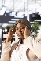 Stressed manager suffering headache, feeling depressed after evaluating disastrous company performance. CEO having painful facial expression while seeing terrible financial data metrics photo
