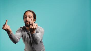Irked man fighting with friend, doing middle finger sign gesturing, isolated over studio background. Outraged person arguing during conversation, doing obscene hand gestures, camera B photo