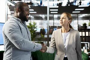 Smiling businessman doing handshake with client in financial startup company, making deal. Upbeat man in office shaking hand of customer after agreeing terms, having discussion photo