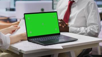 Interviewers meeting with a job candidate about a vacancy next to green screen, HR team attending interview with applicant during recruitment process. Headhunting concept. Camera A. photo
