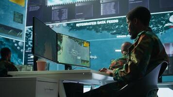 Military personnel in a control center working on data processing, integrating real time surveillance and security protocols essential for national defense and strategic operations. Camera B. photo
