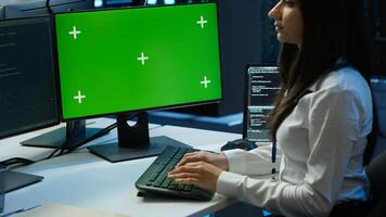 System administrator in data center installing software on green screen computer, troubleshooting issues. IT expert uses mockup PC in server hub, establishing performance benchmarks, camera A photo