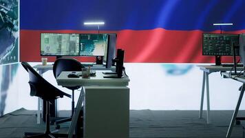 Empty russian army command center with a big screen showing the national flag, working on spreading fake news and propaganda to inflict fear and misinformation. Terrorist ideology. Camera A. photo