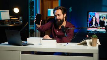 Tech influencer filming technology review of newly released smartphone, unboxing it and presenting specifications to audience. blogger showing phone to subscribers, camera A photo