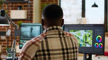 Male creator edits a multimedia project at a modern office, using professional tech tools and editing software to manage timeline editing and production. Work from home. Camera B. photo