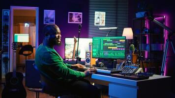 Musician playing piano keyboard and recording tracks for mix and master session, using digital software on pc to create new songs. Sound producer composing music with midi controller tool. Camera B. photo