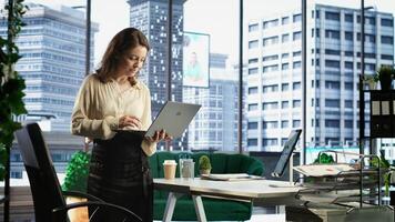 Successful female entrepreneur oversees a strategic review of the company activity, analyzing market trends and setting new priorities. Ensuring the enterprise objectives achievements. Camera B. photo