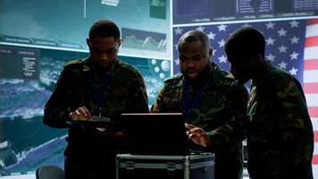 Military officer in a high tech control center engages in cybersecurity operations, protecting classified data from threats and managing digital warfare strategies to maintain state secrets. Camera A. photo