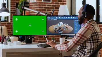 Software developer creates a gear prototype on dual monitors next to chroma key display, home office remote work. Expert does 3D modeling for innovation in the industrial design industry. Camera B. photo