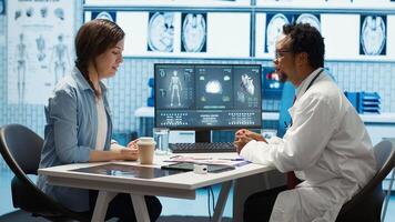 General practitioner giving the right diagnosis to woman patient, attending a checkup consultation in medical cabinet. Doctor explaining x ray imaging and scan results, care management. Camera A. photo