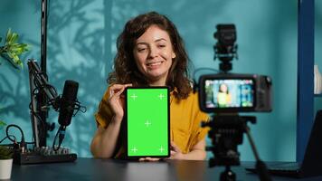 Woman filming tech tutorial on how to repair damaged mockup tablet using professional camera. Engineer teaching fans to install operating system on green screen device, recording with gear, camera A photo