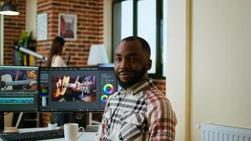 Male filmmaker editing montage on professional software, doing freelance work for a cinematic project using dual monitors. Young man working on a creative process at home. Camera A. photo