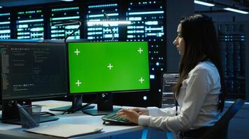 Admin in data center using mockup PC to design, implement and manage gear, ensuring optimal performance and reliability. Expert in server room coding on green screen computer, camera A photo
