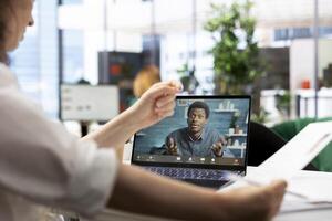 Human resources worker browsing through CVs while in videocall with applicant. HR employer selecting candidates to work for organization, doing teleconference meeting with man photo