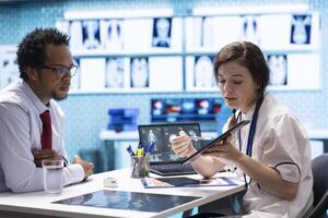 Medical staff reviewing diagnostic reports and results for a patient, focusing on x ray imaging and scan interpretation. Modern medical examination and patient diagnosis at clinic. photo