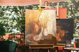 Empty artistic atelier with a rustic watercolor painting displayed on canvas, creative process with acrylic paint in a contemporary art and craft workshop. Masterpiece creation and supplies. photo