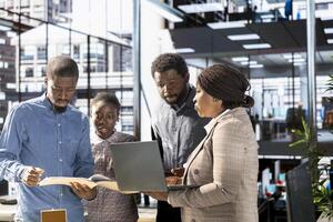 African american executive team are engaged in administrative tasks, reviewing progress reports and corporate data to ensure alignment with company goals for effective management. photo