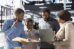 African American team collaborates on a financial planning project in a corporate office, emphasizing teamwork and data analysis to make informed decisions for future firm growth. photo