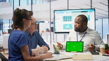 Financial advisor works with a green screen at table with his senior clients, presenting retirement plans and investment options to secure their pension and life savings. Insurance agency. Camera B. photo