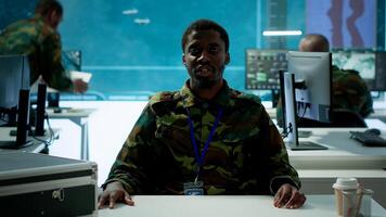 Army personnel in a high tech command center attends a videocall meeting and communicating crucial information from surveillance systems and cctv. Support national security operations. Camera A. photo