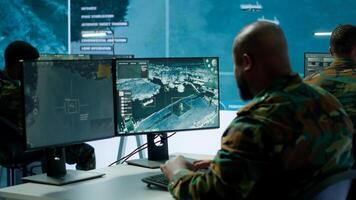 Military crew in a high tech operations command post managing information from radar cctv systems, real time data to support defense missions. Army protocols for national security. Camera A. photo