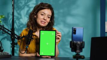 Happy technology expert at home holding newly launched green screen tablet in hand, presenting camera and screen specs. Jolly media star doing chroma key digital device review for viewers, camera A photo