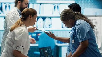 Team of specialists reviewing ecg results in a meeting at a private clinic, analyzing cardiovascular system on a radiography for disease prevention. Consulting scans and records. Camera A. photo