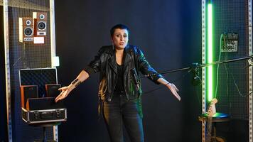 Heavy metal performer acting uncertain and shrugging in doubt, being clueless and uncertain about an answer. Confused doubtful woman artist having no idea about something. Camera B. photo