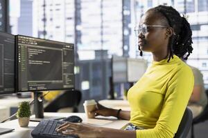 Back end developer managing cloud computing resources and platforms to train machine learning models. IT specialist monitoring and maintaining company systems, checking code on PC monitor photo