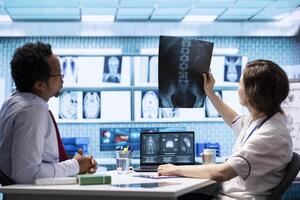 Medical specialist showing x ray diagnostic report and blood test analysis to a patient at consultation in cabinet, providing advice and treatment on health insurance. Scan medical results. photo