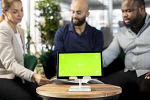Isolated screen tablet in front of employees checking progress done on customer commissioned project. Close up of mockup device next to office clerks reading data statistics on paperwork after audit photo