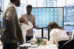 Business associates sharing ideas in a corporate briefing meeting, utilizing interactive boards to present detailed project reports and align on key performance indicators and objectives. photo