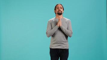 Pious man praying to his god, asking for forgiveness. Spiritual person doing worship hand gesturing, confessing, begging for pardon, isolated over studio background, camera A photo