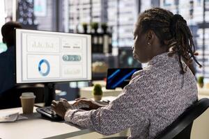 Businesswoman analyzing performance metrics on her computer at the workplace, office life. Engaged in strategic planning, she reviews data to support company objectives for successful outcomes. photo