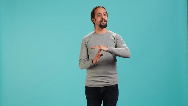 Portrait of assertive man asking for timeout, doing hand gestures, feeling fatigued. Unhappy person doing vehement pause sign gesturing, wishing for break, studio background, camera A photo