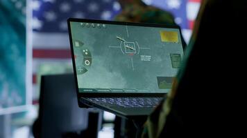 Intelligence officers in american military uniforms work on computers in a command post, managing surveillance and data analysis. Support global operations for the US government. Camera A. photo