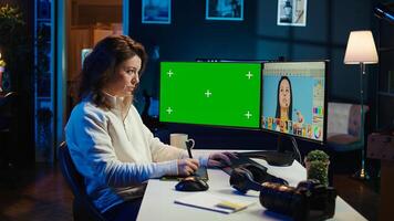 Photo editor using green screen monitor to look at editorial pictures taken with professional camera for fashion magazine. Freelancer browsing images on mockup PC, using graphic tablet, camera B
