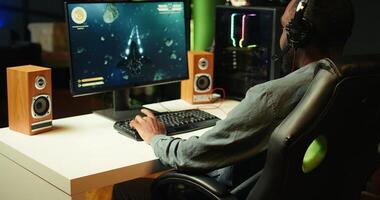 Gamer using headphones to discuss with mates while playing online SF videogame, close up. Close up enjoying futuristic coop spaceship flying arcade game with friends, chatting on internet, camera B photo