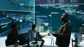 Military specialists work in a high tech command post center, focusing on cybersecurity, surveillance and data protection to ensure the security and integrity of national information. Camera B. photo