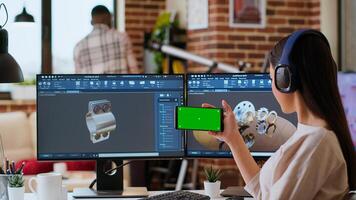 Creative professional uses 3D modeling software to design industrial prototypes, using copy space display. Home office setup showcases innovation, technology and modern tech tools. Camera B. photo