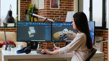 Professional industrial designer working with CAD software on dual monitors, creating 3D prototypes for a tech driven environment. 3D modeling software for innovative design. Camera B. photo