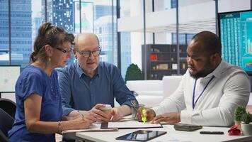 Senior people consulting with their financial banker about retirement plans, focusing on securing their financial future. Receiving professional advice for income and pension. Camera B. photo