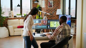 Creative interracial couple collaborating on editing process, discussing multiple ways to use the professional software and color wheel. Diverse multiethnic man and woman at home. Camera A. photo