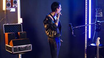 Rebellious rock performer protesting with a hush mute sign in studio, symbolizing no hate and anti bullying social messages. Rocker with leather jacket asking to be silent. Camera A. photo
