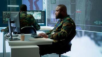 Army intelligence specialists using advanced computer systems and satellite data to enhance national security, critical information. Soldiers planning for mission in high tech control room. Camera A. photo