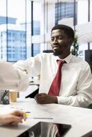 HR worker reviewing happy candidate, doing handshake after asking questions about qualifications. Cheerful applicant at interview closing deal after proving skills and enthusiasm for job opportunity photo