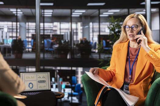 Female boss discussing about tasks on a phone call during problem solving meeting, contacting employees via mobile phone call. CEO discussing about latest project developments. photo