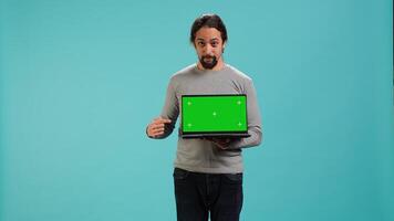 Portrait of worker holding isolated screen laptop, doing important work for company, studio background. Employee with chroma key device at work solving job tasks, camera A photo